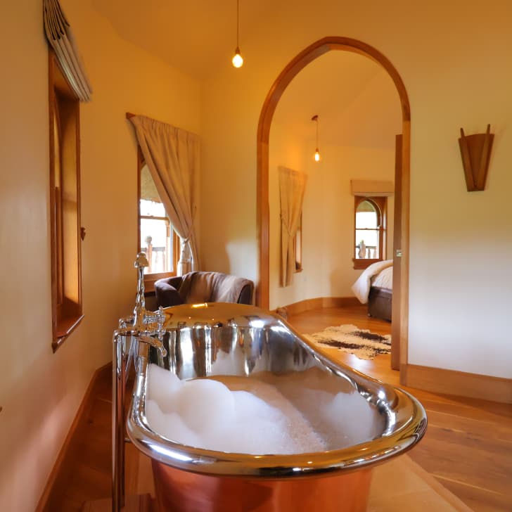 Copper bath tub with open plan view into master bedroom